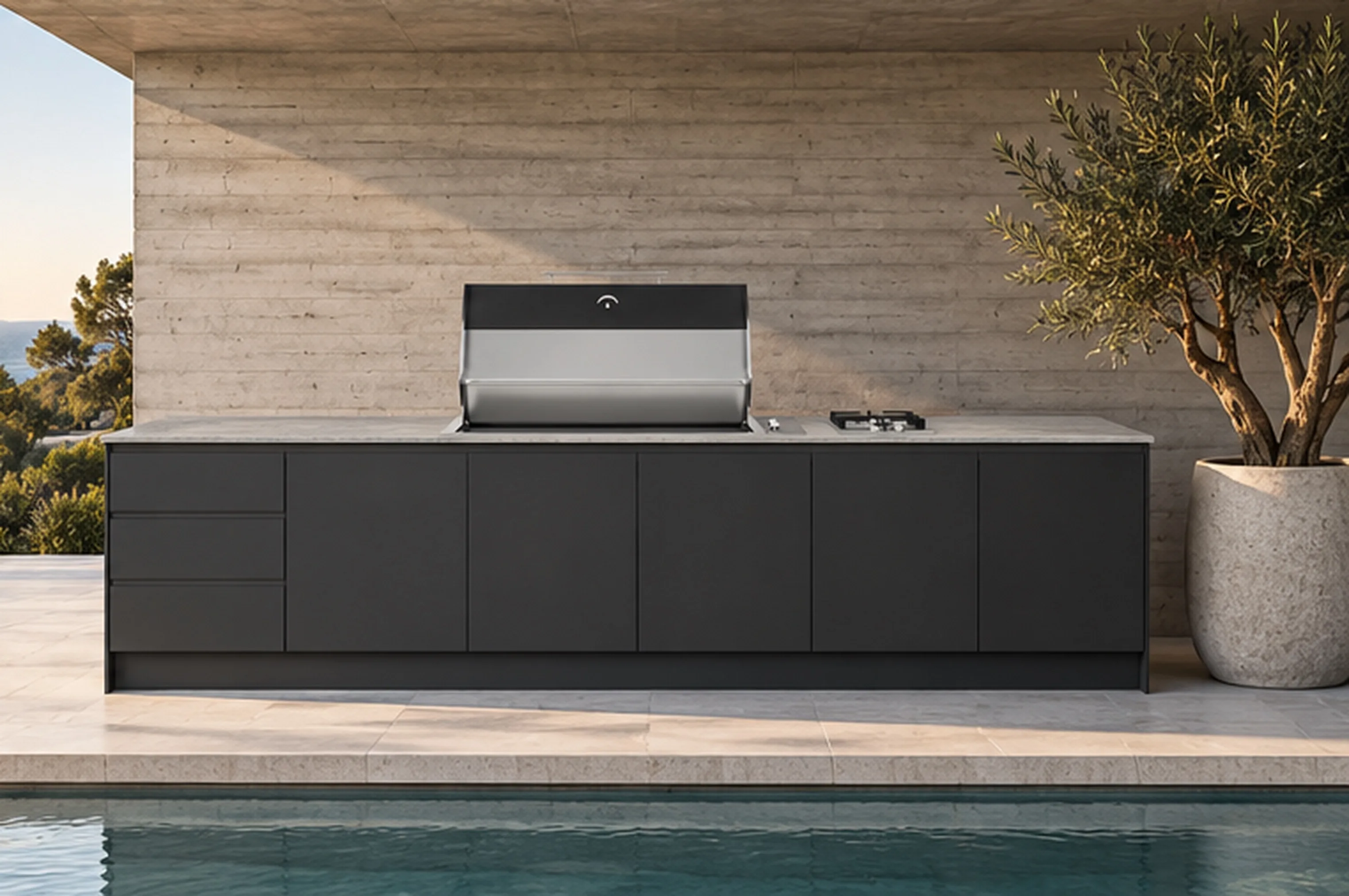 A charcoal outdoor kitchen with a light stone-look benchtop and integrated barbecue beside a pool.